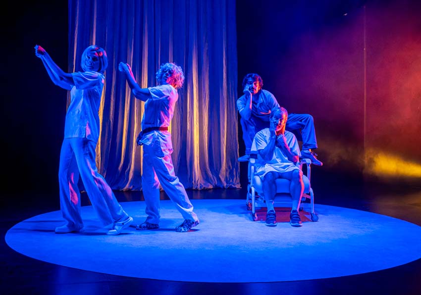 event image:Four people on stage, three standing and one in a wheelchair